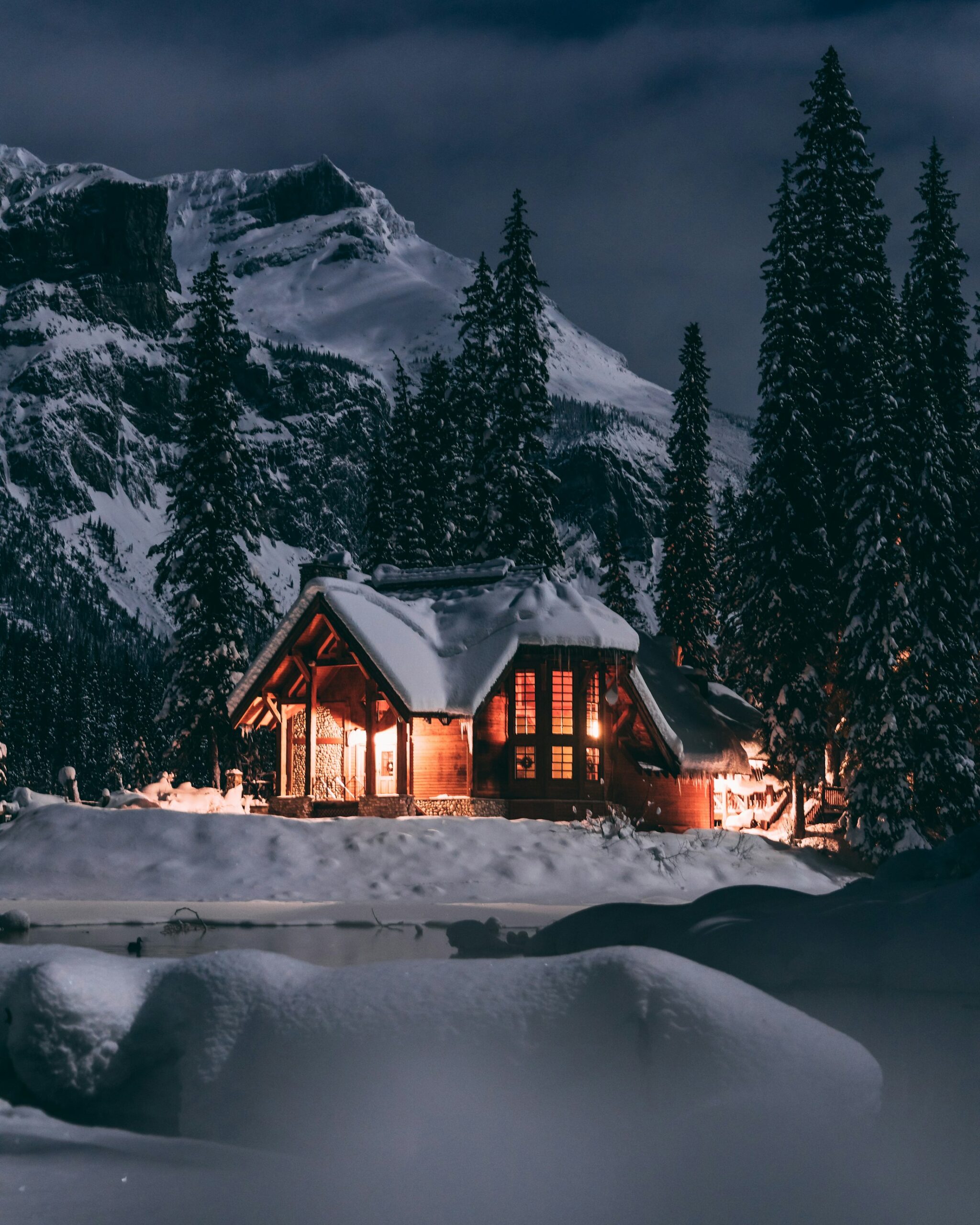 Chalet illuminé dans la neige au crépuscule
